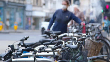 Defokussierte-Schwenkaufnahme,-Die-Fahrradständer-und-Stadtmenge-Enthüllt